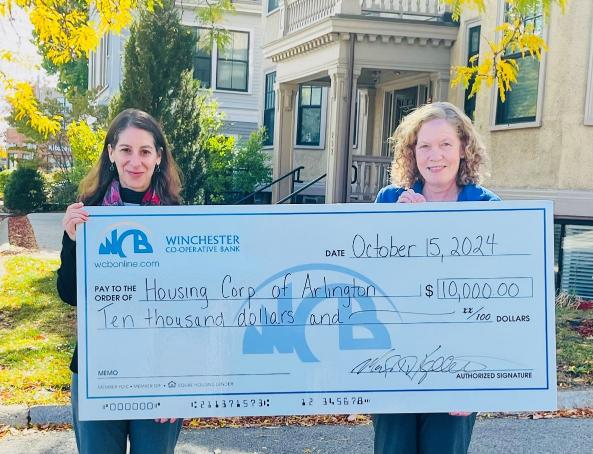 2 women holding big check