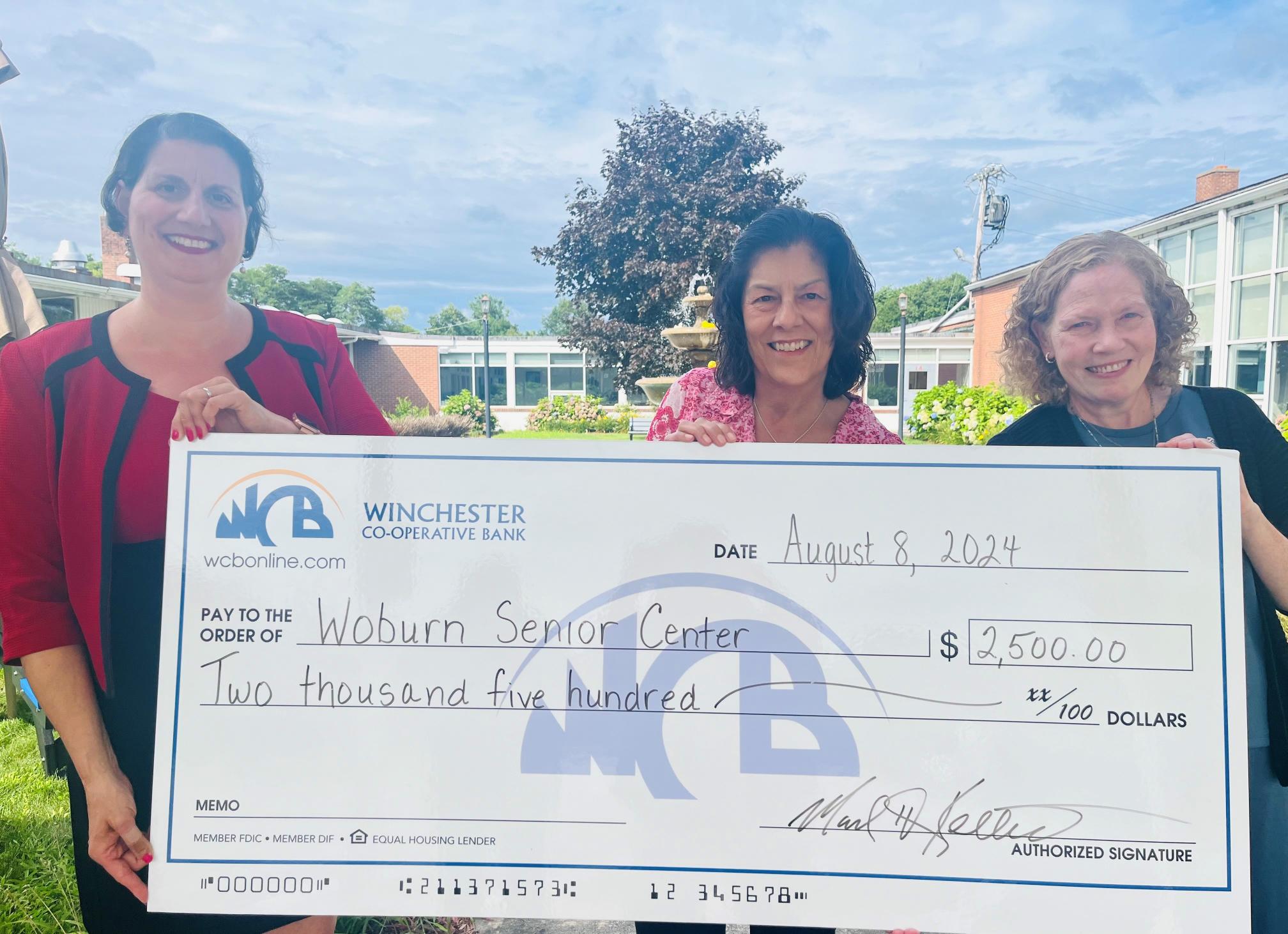 group of women holding a check